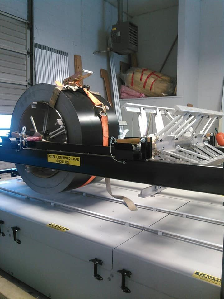 Portable roof panel machine with a coil of metal roofing